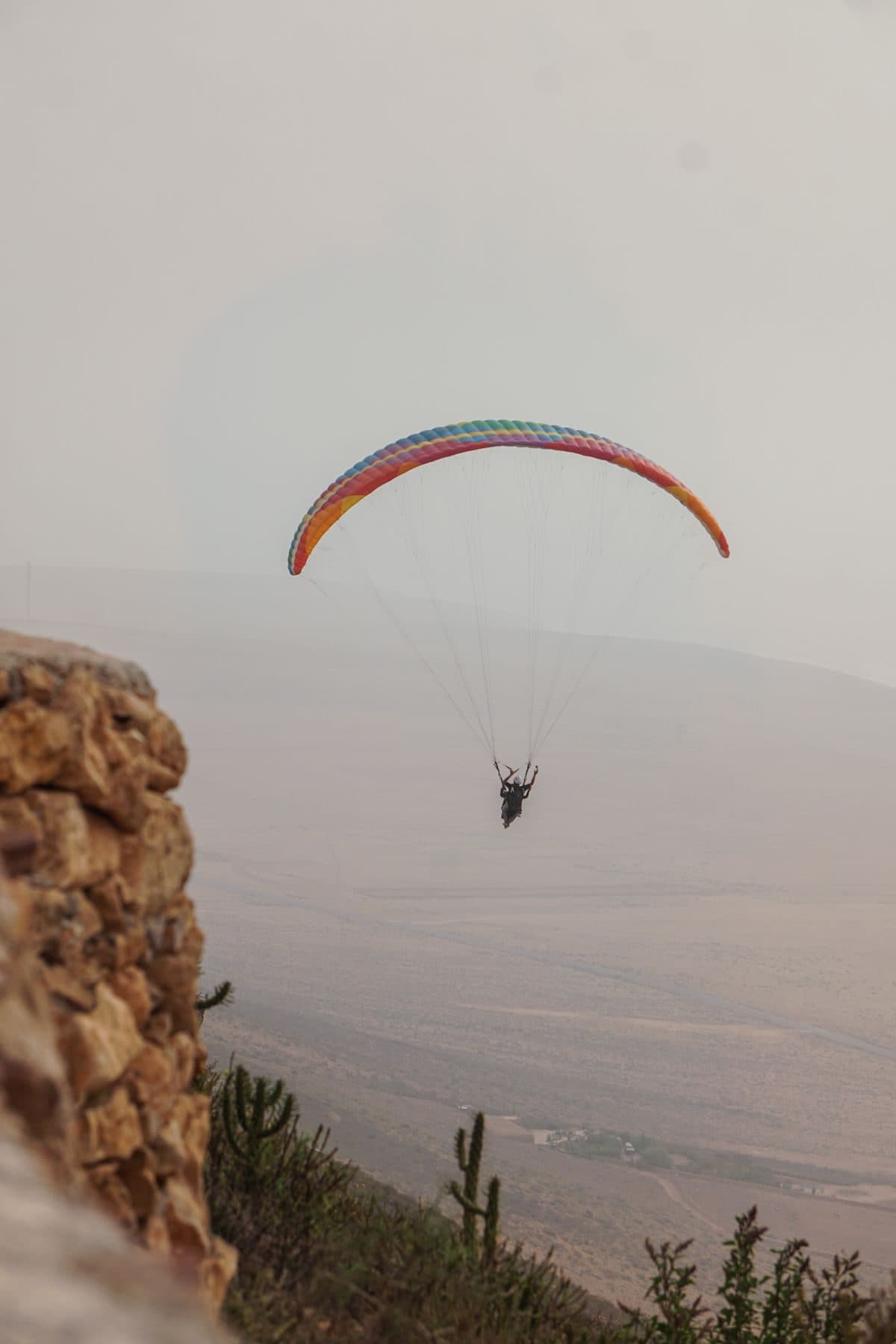 Parapente au-dessus d’une crête rocheuse et désertique